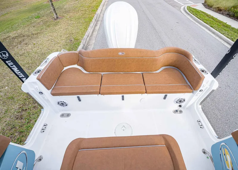 Slide: The Image of 2025 Sea Hunt Ultra 255 SE boat interior with brown seating and white deck. - 17