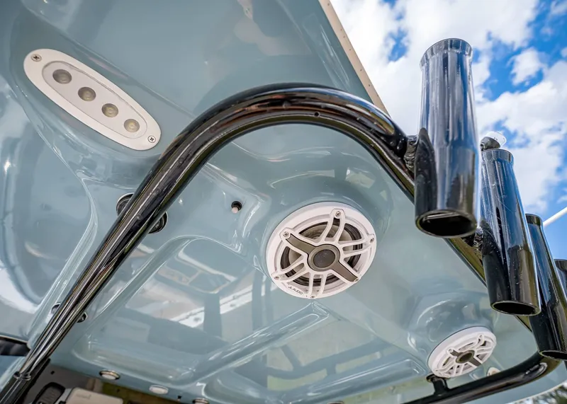 Slide: The Image of 2025 Sea Hunt Ultra 255 SE boat speakers and rod holders under blue sky. - 19