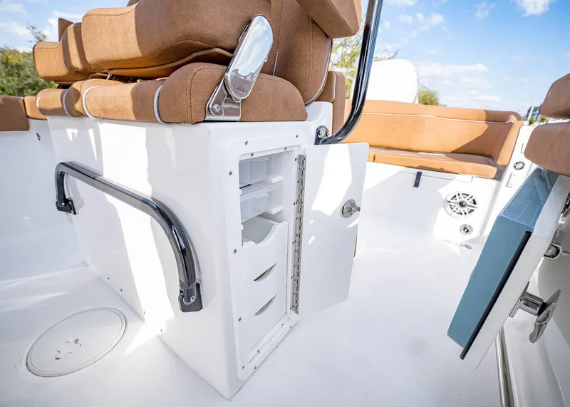 Slide: The Image of 2025 Sea Hunt Ultra 255 SE boat interior with open storage compartment and cushioned seating. - 20