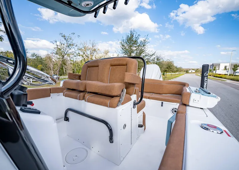 Slide: The Image of 2025 Sea Hunt Ultra 255 SE boat interior with brown seating and clear sky. - 21