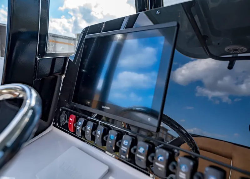 Slide: The Image of Dashboard of 2025 Sea Hunt Ultra 255 SE boat with Garmin display and control panel. - 26