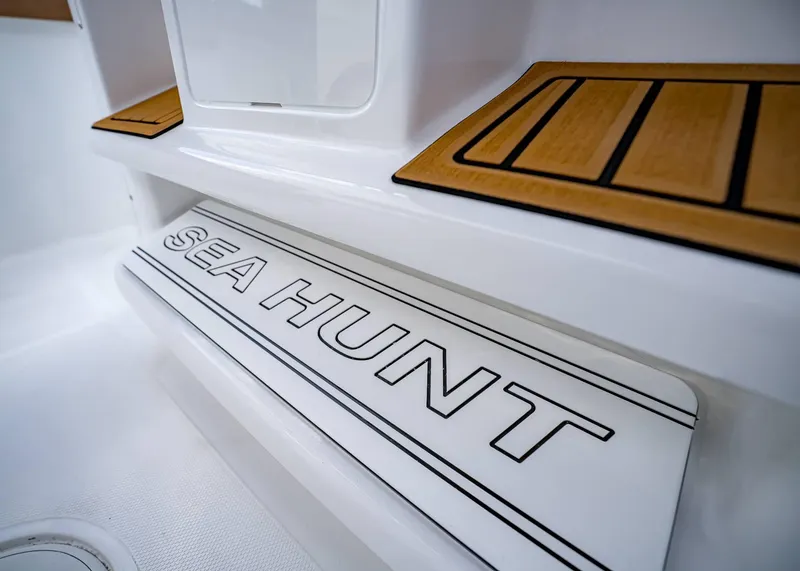 Slide: The Image of 2025 Sea Hunt Ultra 255 SE boat interior with branded step and wood accents. - 28