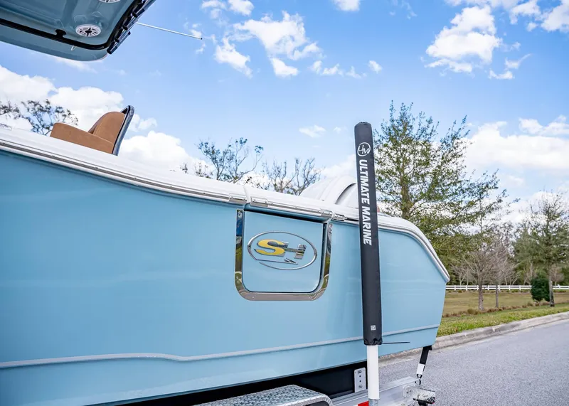 Slide: The Image of 2025 Sea Hunt Ultra 255 SE boat on trailer, blue exterior, clear sky background. - 3