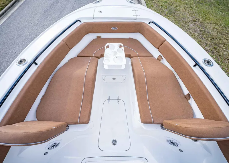 Slide: The Image of 2025 Sea Hunt Ultra 255 SE boat with brown cushioned seating and white deck. - 35