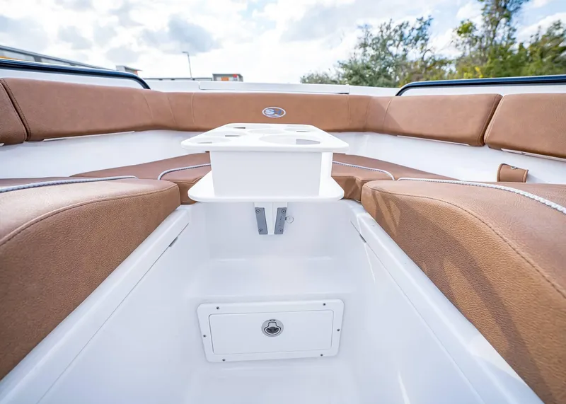 Slide: The Image of Interior view of 2025 Sea Hunt Ultra 255 SE boat with brown seating and white table. - 36