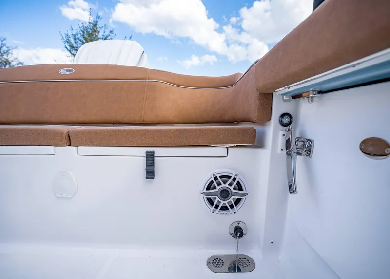 Slide: The Image of 2025 Sea Hunt Ultra 255 SE boat interior with brown seating and speaker. - 9