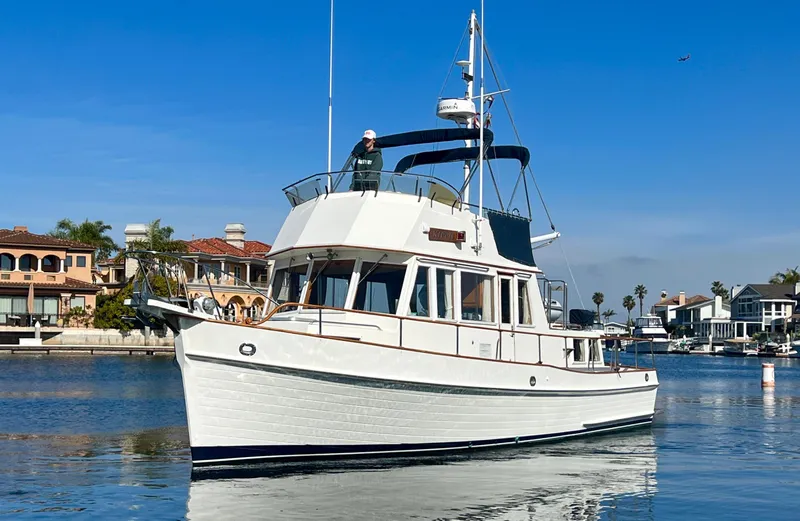 Slide: The Image of 1988 Grand Banks 36 Classic yacht cruising in a scenic waterfront setting. - 2