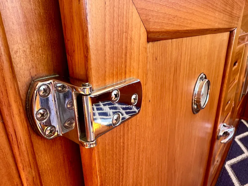 Slide: The Image of Polished hinge on 1988 Grand Banks 36 Classic wooden door. - 22