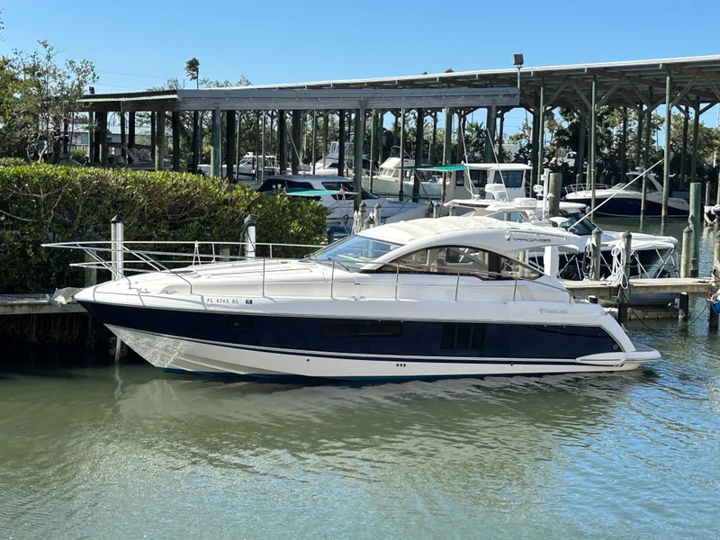 The Image of 2013 Fairline Targa 38 Open yacht docked in a marina, surrounded by water and greenery. - 0