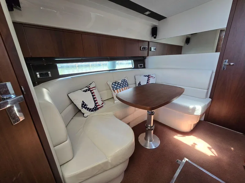 Slide: The Image of 2013 Fairline Targa 38 Open interior with white leather seating and nautical-themed cushions. - 23