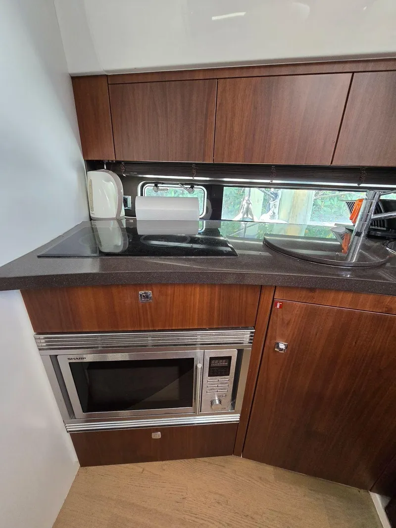 Slide: The Image of 2013 Fairline Targa 38 Open yacht kitchen with microwave and wooden cabinets. - 24