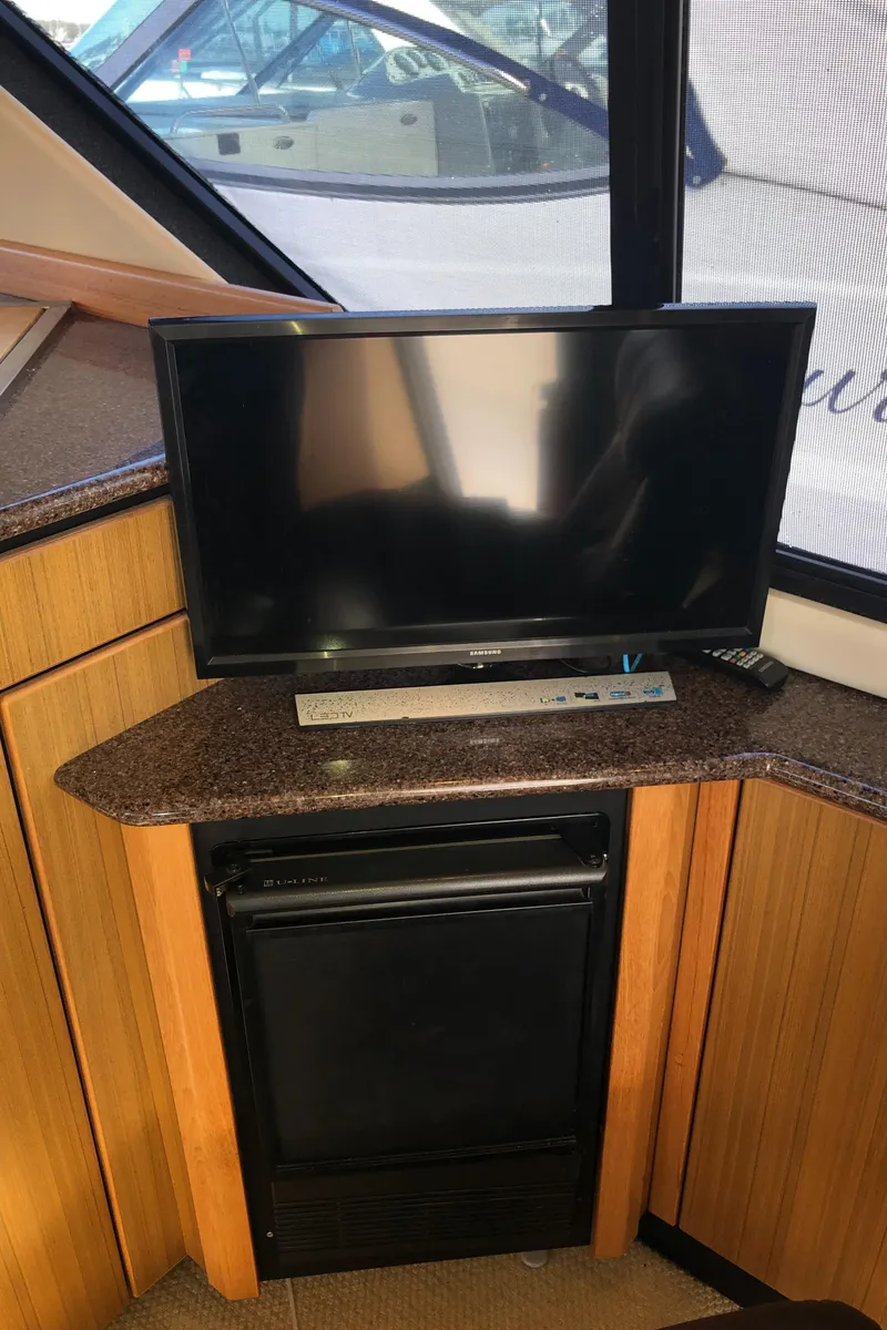 Slide: The Image of 2002 Bayliner 39 Motor Yacht interior with TV and mini fridge. - 10