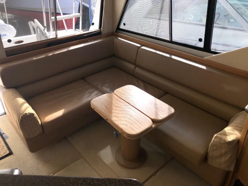 Slide: The Image of Interior of 2002 Bayliner 39 Motor Yacht with beige seating and wooden table. - 11