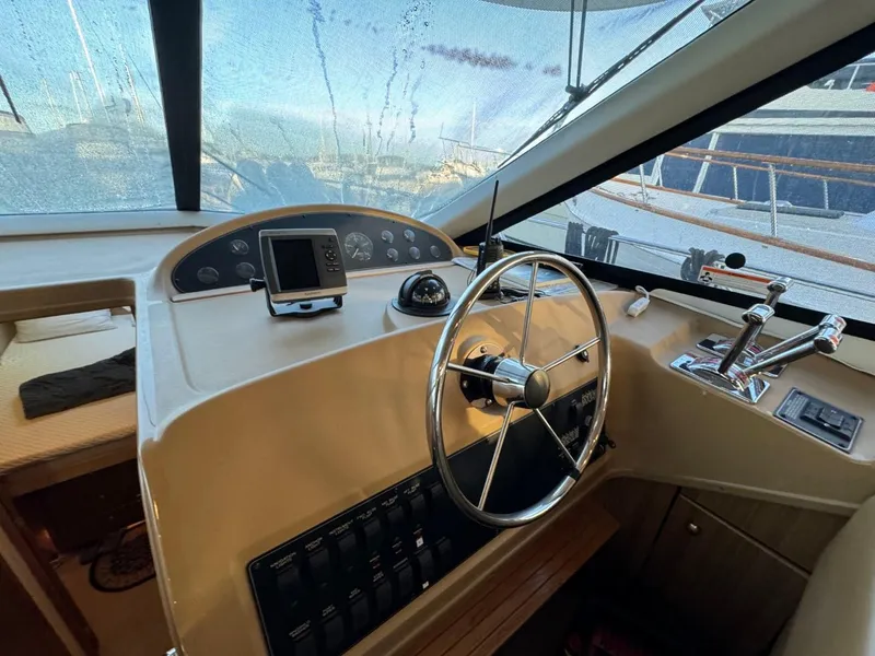 Slide: The Image of 2002 Bayliner 39 Motor Yacht helm with steering wheel, controls, and navigation equipment. - 12