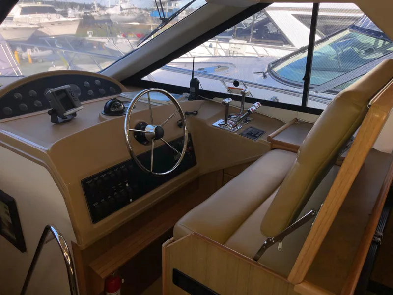 Slide: The Image of 2002 Bayliner 39 Motor Yacht helm with steering wheel and control panel. - 13