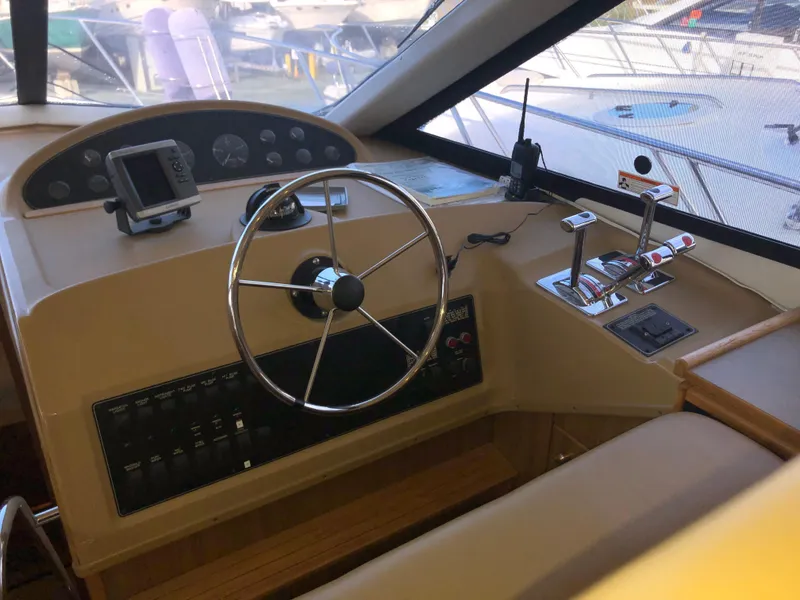 Slide: The Image of 2002 Bayliner 39 Motor Yacht helm with steering wheel and control panel. - 14