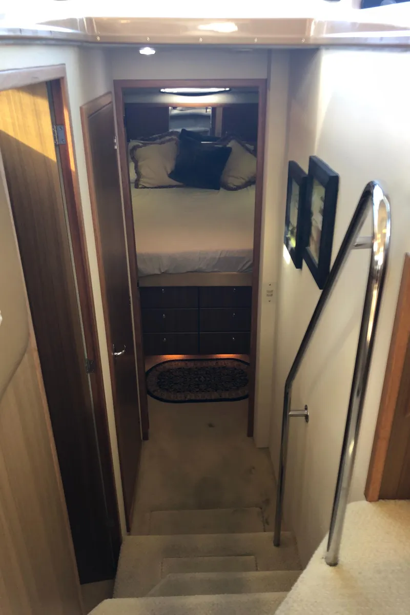 Slide: The Image of Interior view of 2002 Bayliner 39 Motor Yacht, featuring cozy bedroom and staircase. - 22