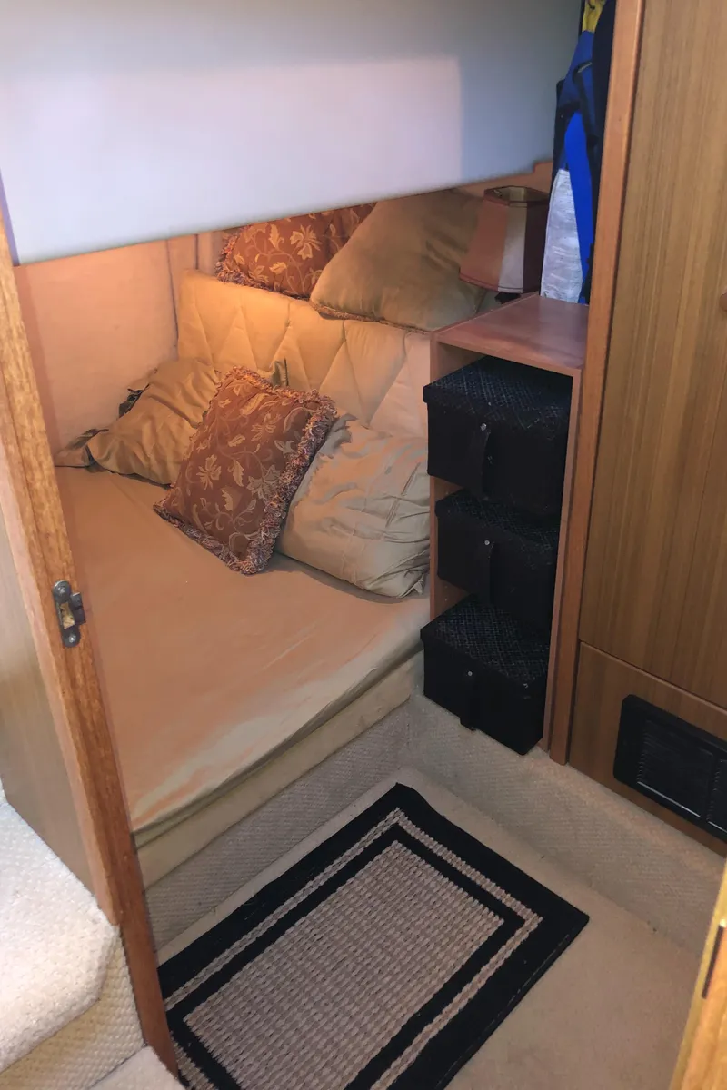 Slide: The Image of Cozy cabin interior of 2002 Bayliner 39 Motor Yacht with plush bedding and storage. - 23
