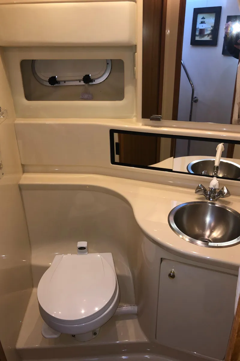 Slide: The Image of 2002 Bayliner 39 Motor Yacht bathroom with toilet, sink, and mirror. - 24