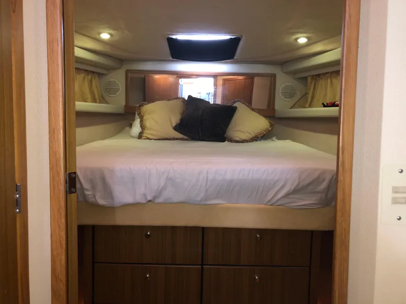Slide: The Image of Cozy bedroom in 2002 Bayliner 39 Motor Yacht with plush bedding and wooden cabinetry. - 27