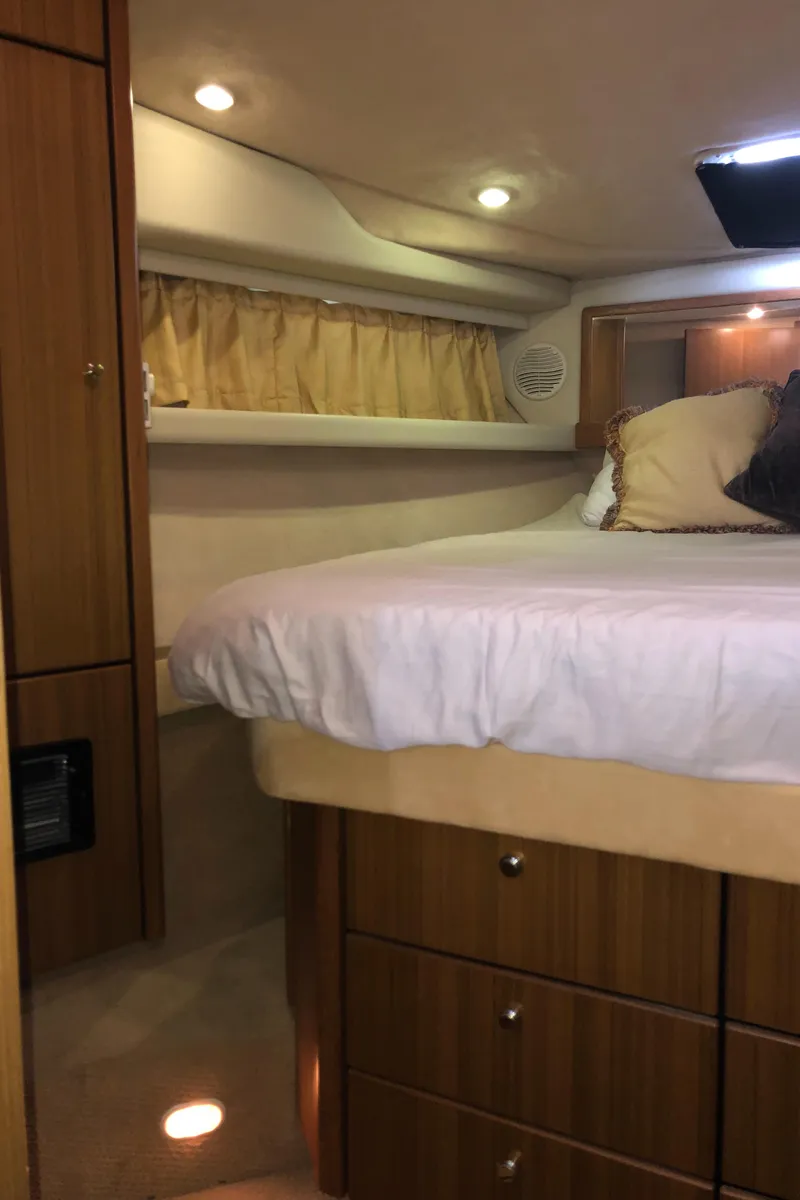 Slide: The Image of 2002 Bayliner 39 Motor Yacht bedroom with cozy bed and wooden cabinetry. - 28