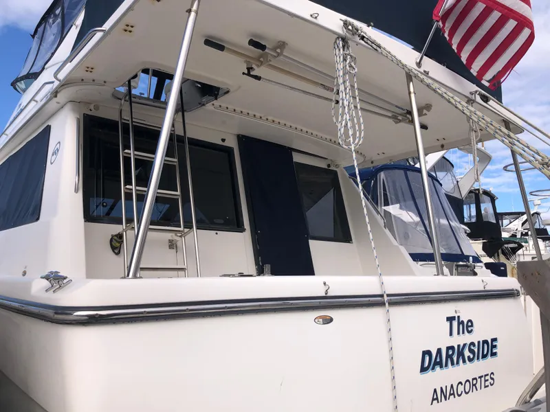 Slide: The Image of 2002 Bayliner 39 Motor Yacht docked, featuring "The Darkside" name and American flag. - 3