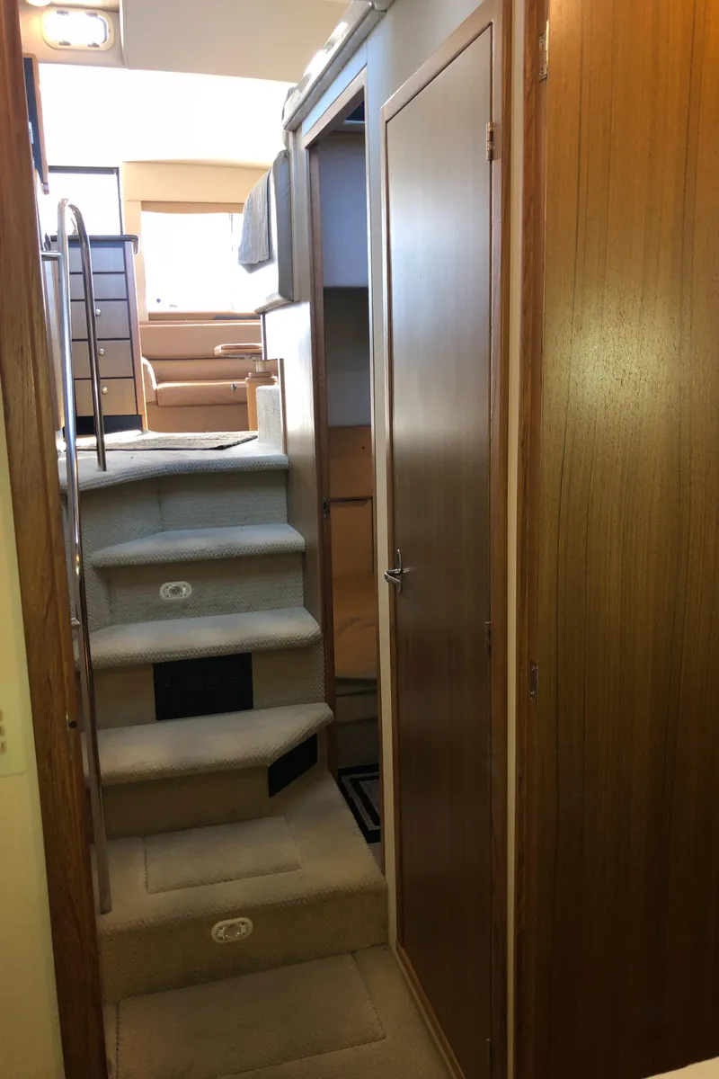 Slide: The Image of Interior view of 2002 Bayliner 39 Motor Yacht, featuring carpeted stairs and wooden paneling. - 32
