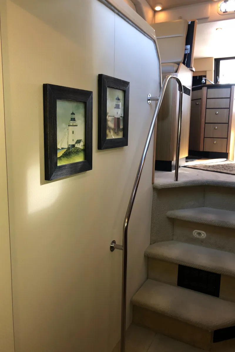 Slide: The Image of Interior of 2002 Bayliner 39 Motor Yacht with framed lighthouse art and carpeted stairs. - 33
