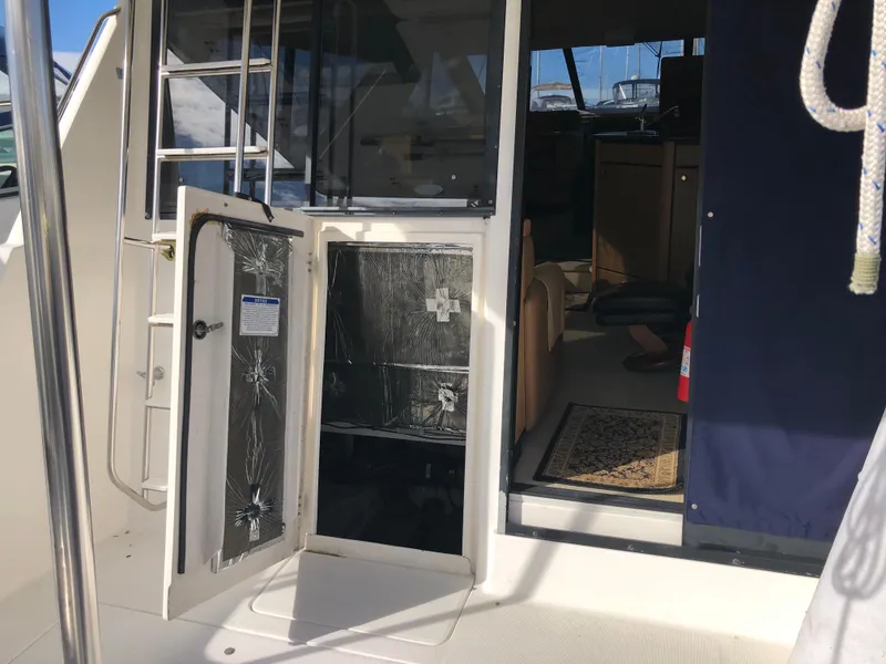 Slide: The Image of 2002 Bayliner 39 Motor Yacht interior view with open door and visible seating area. - 35