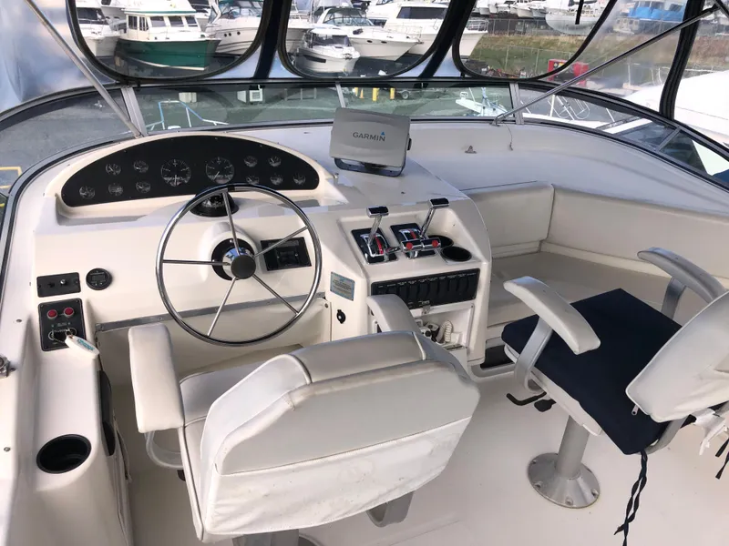 Slide: The Image of 2002 Bayliner 39 Motor Yacht helm with steering wheel, controls, and seating. - 4