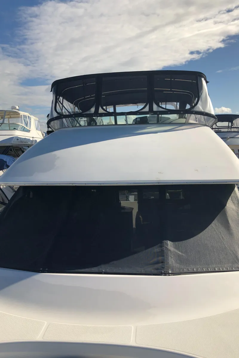 Slide: The Image of 2002 Bayliner 39 Motor Yacht with sleek design, docked under a clear blue sky. - 46