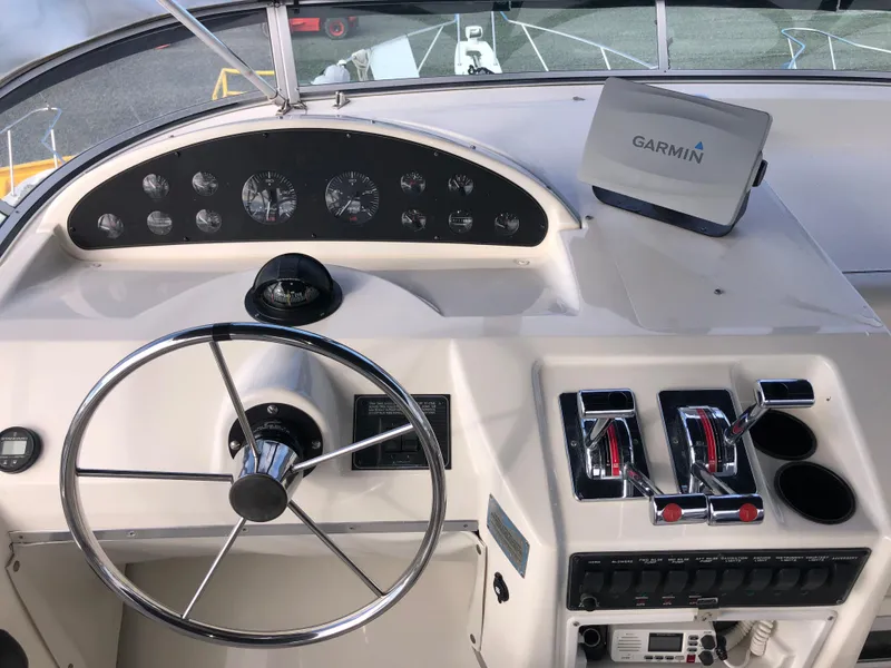 Slide: The Image of 2002 Bayliner 39 Motor Yacht helm with Garmin navigation, steering wheel, and control panel. - 6