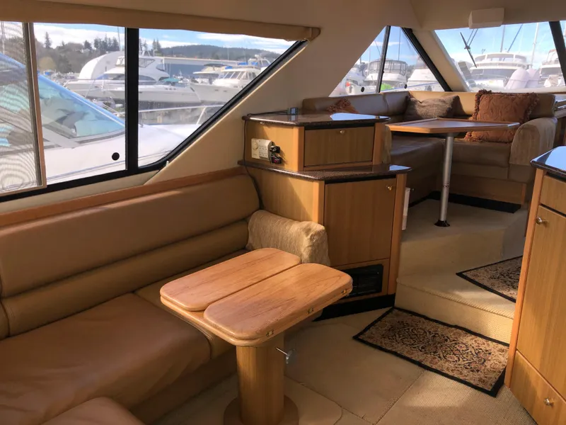 Slide: The Image of Interior of 2002 Bayliner 39 Motor Yacht with cozy seating and wooden accents. - 8
