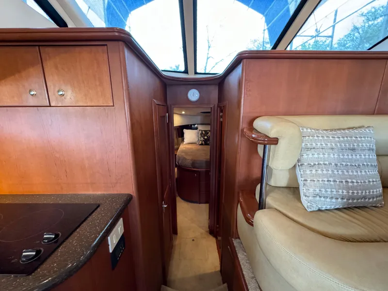 Slide: The Image of Interior of 2006 Silverton 43 Sport Bridge yacht, featuring wood cabinetry and cozy seating. - 21