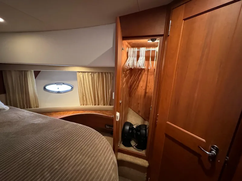 Slide: The Image of 2006 Silverton 43 Sport Bridge cabin interior with bed, closet, and porthole window. - 27