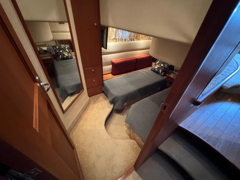 Slide: The Image of 2006 Silverton 43 Sport Bridge interior cabin with twin beds and wooden furnishings. - 28