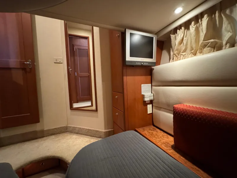 Slide: The Image of 2006 Silverton 43 Sport Bridge cabin interior with TV, bed, and wooden furnishings. - 30