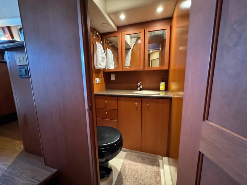Slide: The Image of Luxurious bathroom interior of 2006 Silverton 43 Sport Bridge yacht, featuring wood cabinetry. - 32
