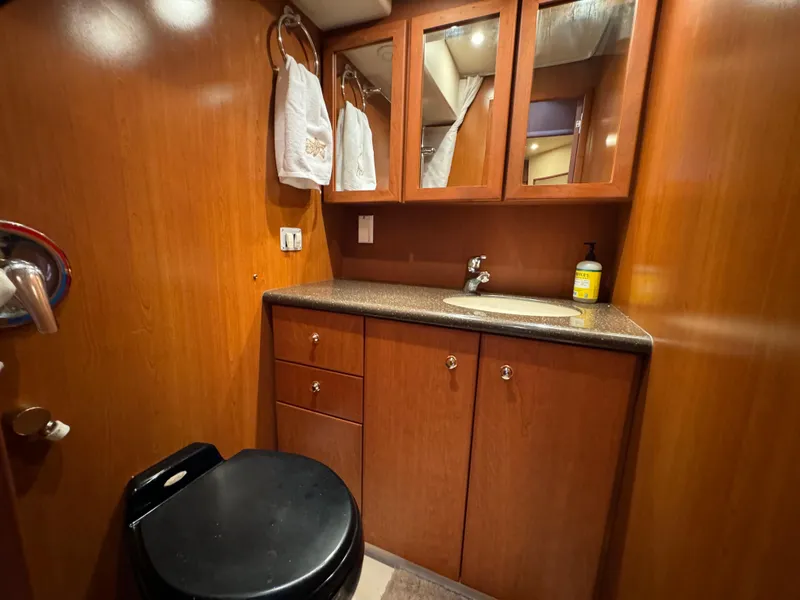 Slide: The Image of 2006 Silverton 43 Sport Bridge bathroom with wood cabinetry, sink, and mirror. - 33