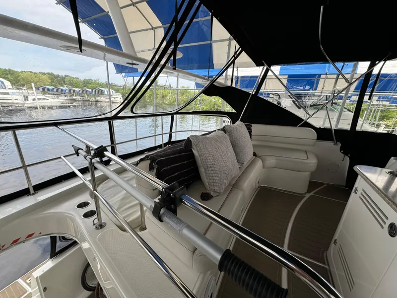 Slide: The Image of 2006 Silverton 43 Sport Bridge interior with seating, cushions, and marina view. - 37