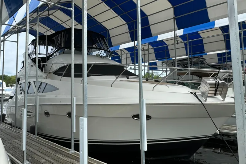 Slide: The Image of 2006 Silverton 43 Sport Bridge yacht docked under a blue and white canopy. - 4