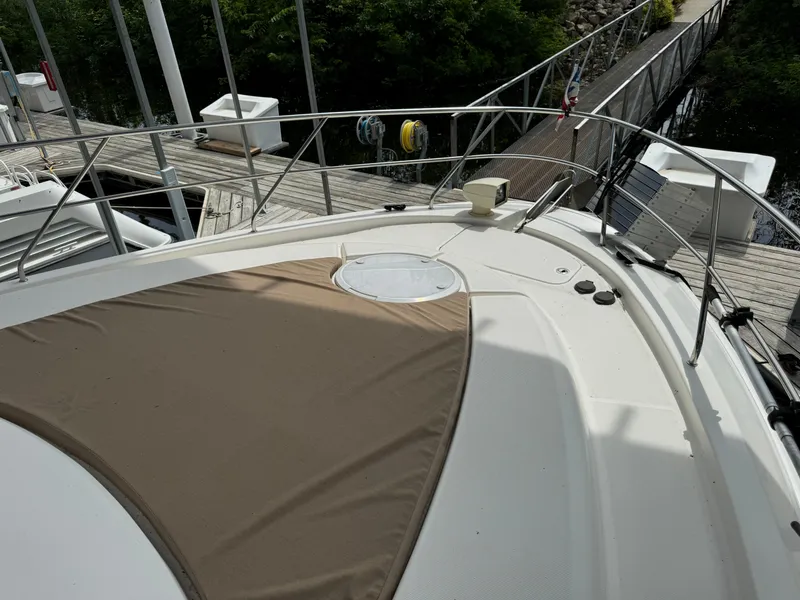 Slide: The Image of 2006 Silverton 43 Sport Bridge yacht deck with tan cover, docked at marina. - 50