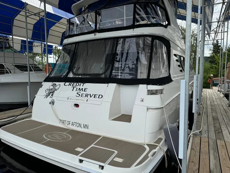 Slide: The Image of 2006 Silverton 43 Sport Bridge yacht docked, featuring "Credit Time Served" on the stern. - 6