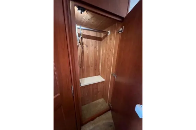 Slide: The Image of 2006 Silverton 43 Sport Bridge wooden closet interior with hanging rod and shelf. - 72