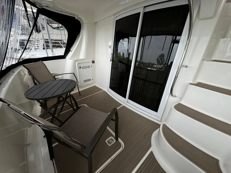 Slide: The Image of 2006 Silverton 43 Sport Bridge yacht deck with seating and stairs. - 8
