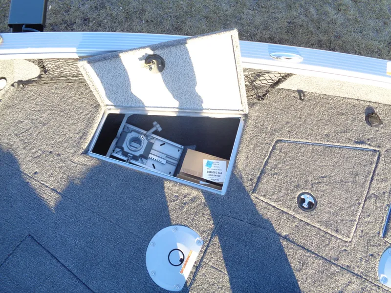 Slide: The Image of 2025 Lund 1875 Pro Guide boat storage compartment with open hatch and equipment inside. - 16