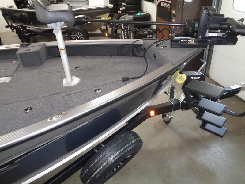 Slide: The Image of 2025 Lund 1875 Pro Guide boat with Minn Kota trolling motor in a showroom. - 28