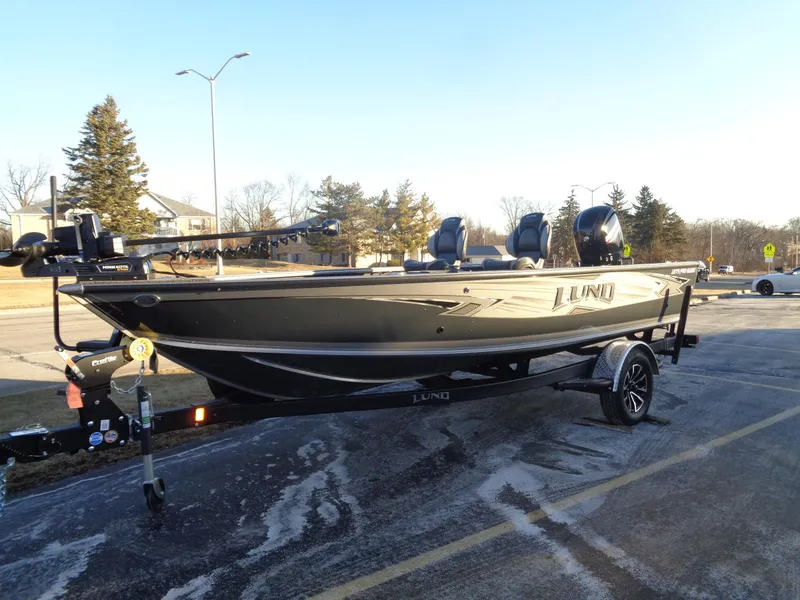 Slide: The Image of 2025 Lund 1875 Pro Guide boat on trailer in parking lot, sunny day. - 3