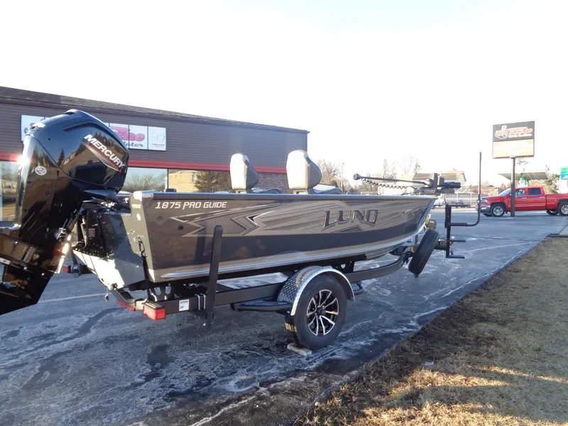 Slide: The Image of 2025 Lund 1875 Pro Guide boat on trailer, parked outdoors. - 4