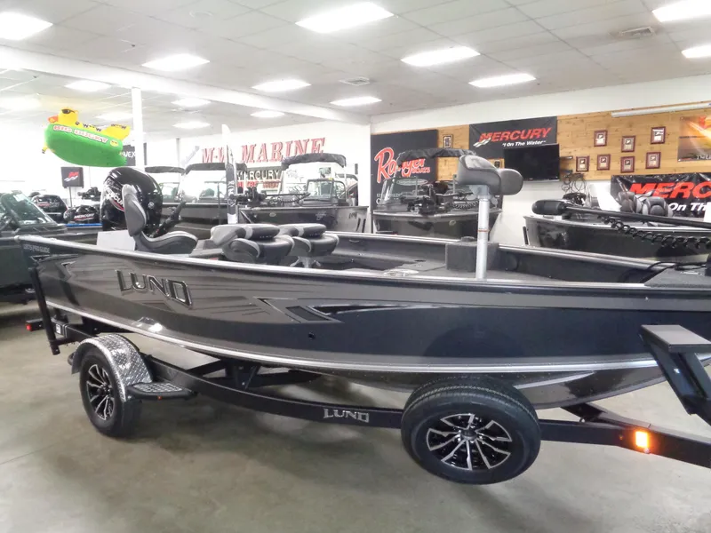 Slide: The Image of 2025 Lund 1875 Pro Guide boat displayed in showroom with Mercury signage. - 6